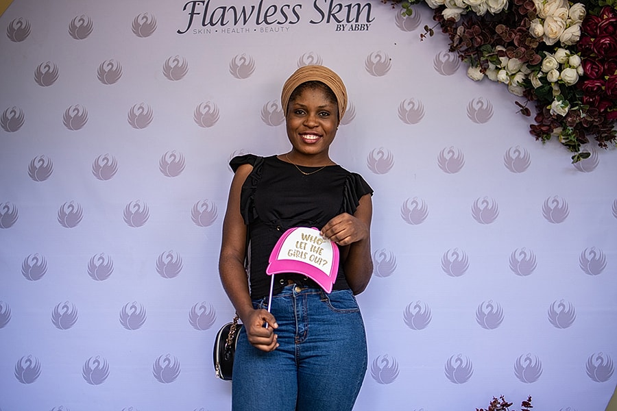 Smiling woman holding a playful sign backdrop.