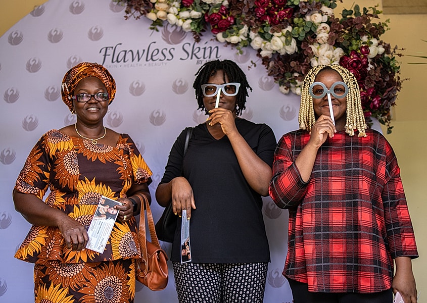 Three women playfully posing with props.