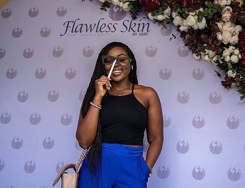 Smiling woman with stylish glasses at event.