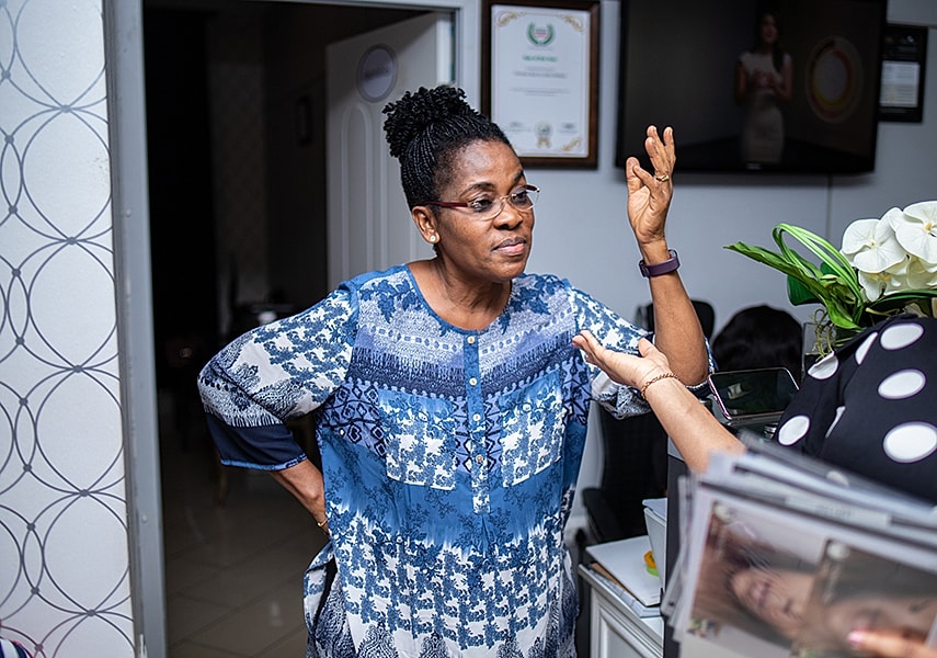 Woman engaging in conversation, wearing blue attire.