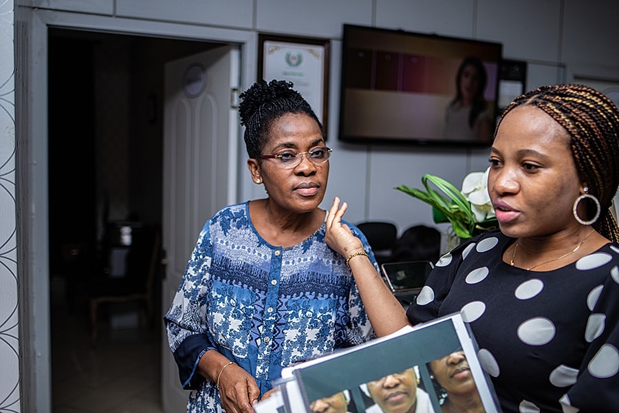 Two women engaged in conversation in an office.