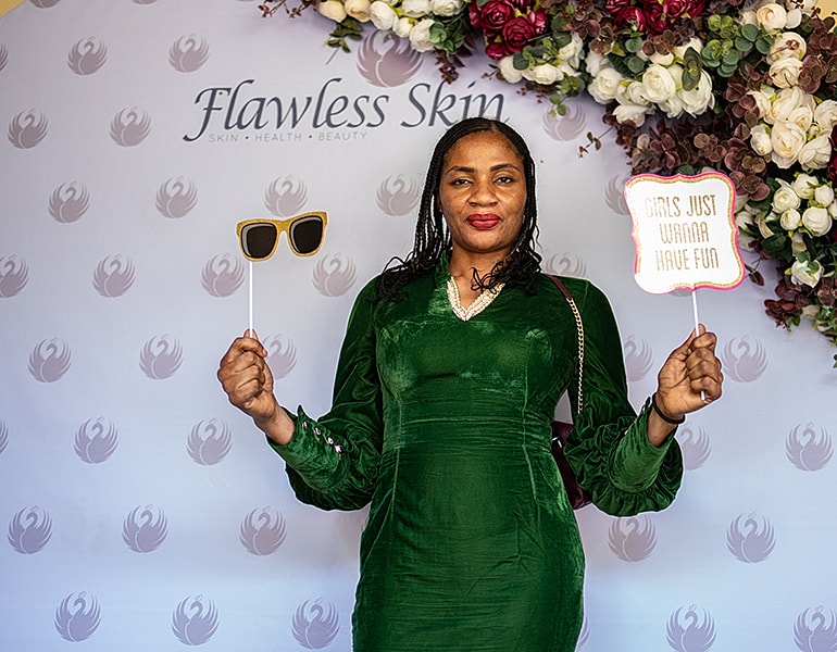 Woman holding props at Flawless Skin event.