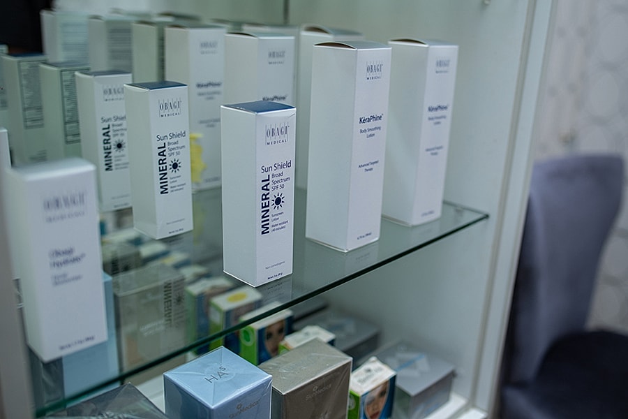 Skincare products displayed on a glass shelf.