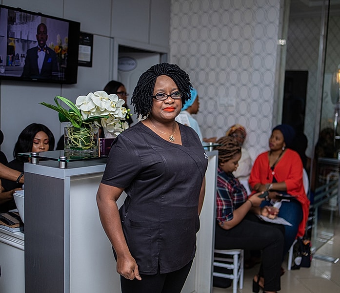 Woman in black outfit at beauty event.