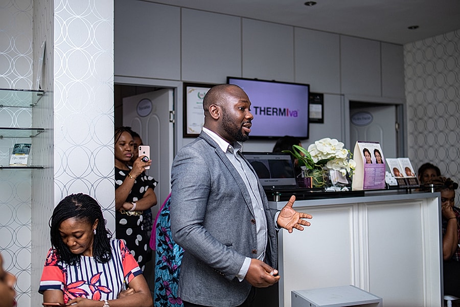 Speaker presenting in modern clinic setting.