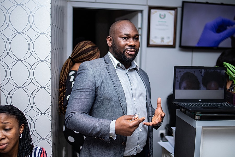 Man speaking in an office setting with laptop.