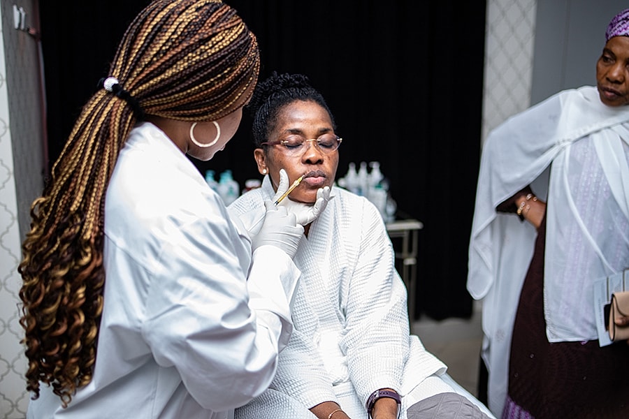 Woman receiving skincare treatment in clinic setting.