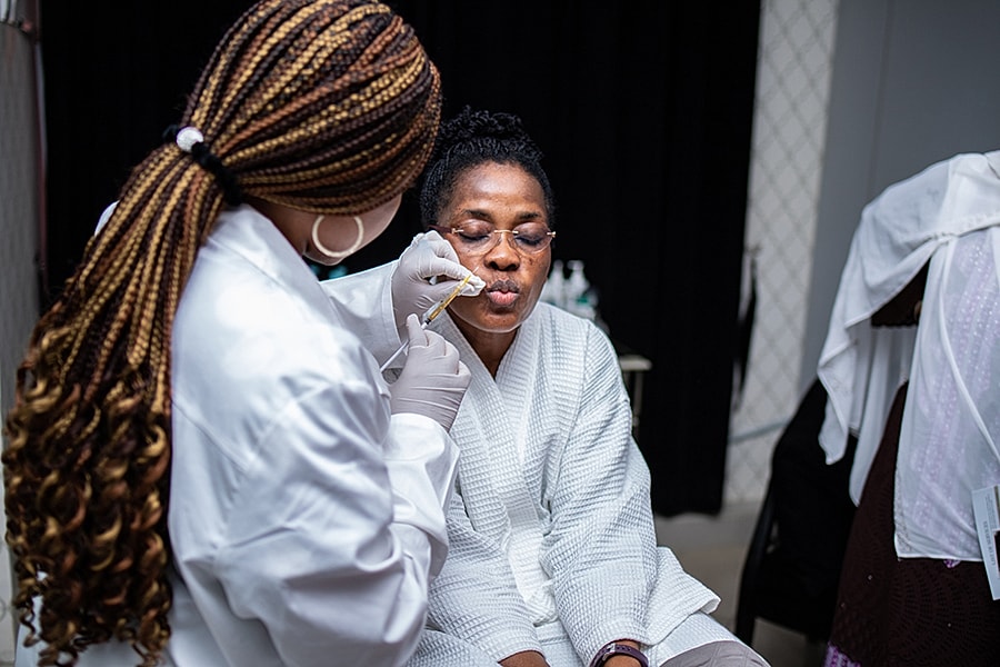 Woman receiving beauty treatment in spa setting.