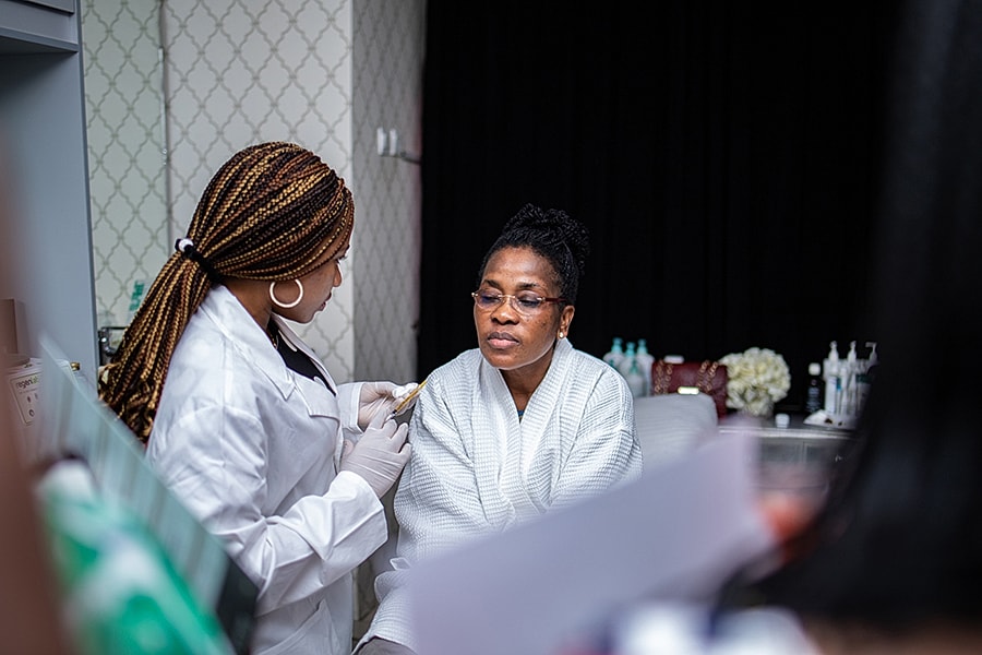 Patient receiving skincare treatment in clinic setting.