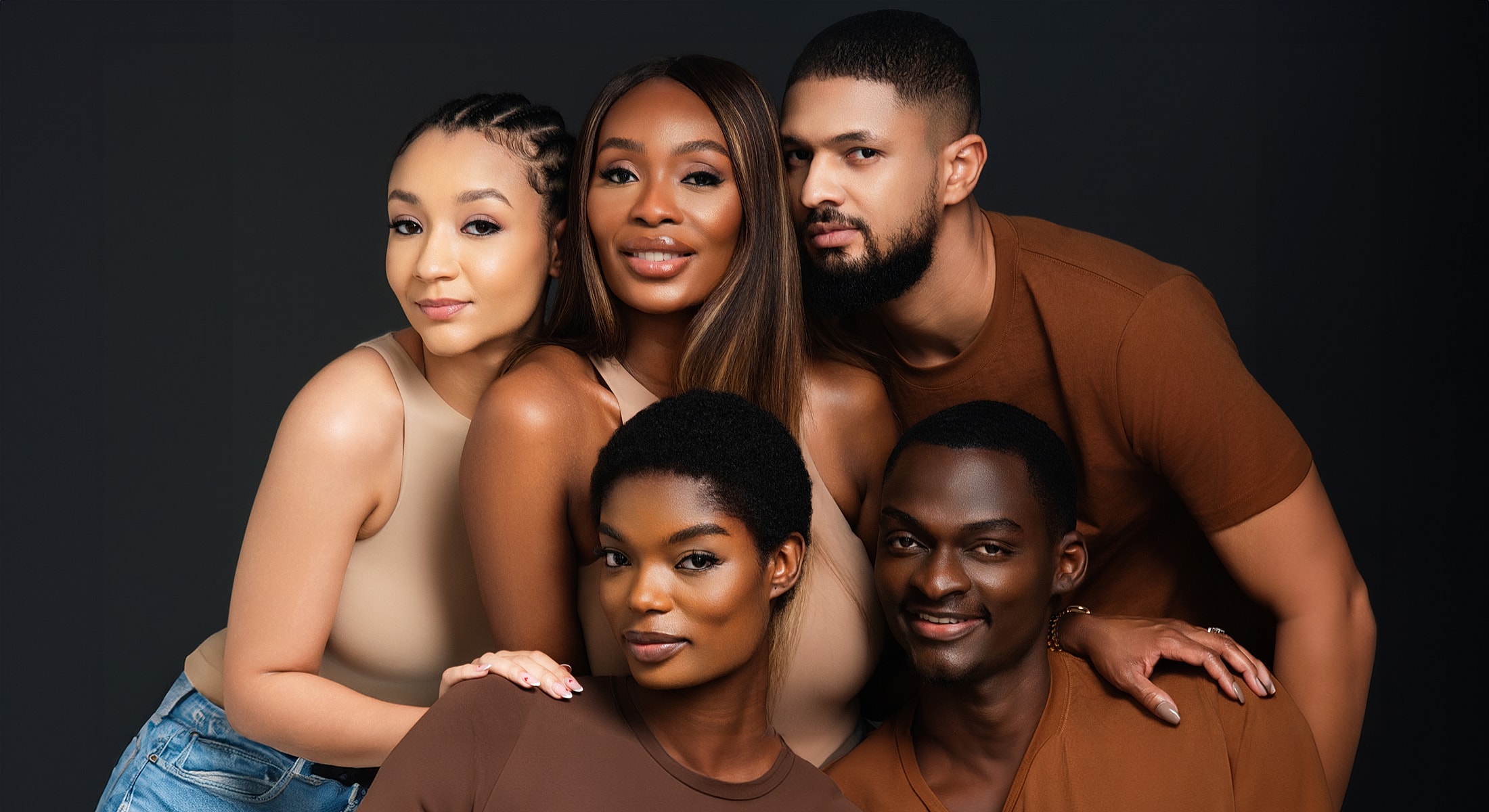 Group portrait of five diverse individuals smiling.