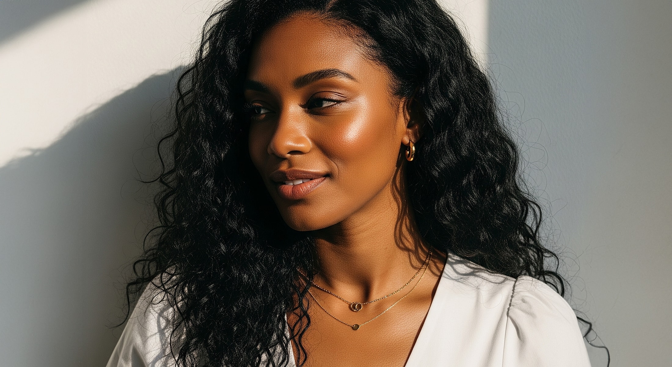 Abuja Anti Aging Treatment model with curly hair illuminated by sunlight.