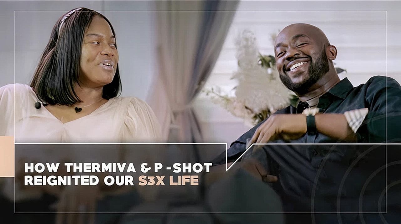 Excited person sitting on a couch, hands clasped.