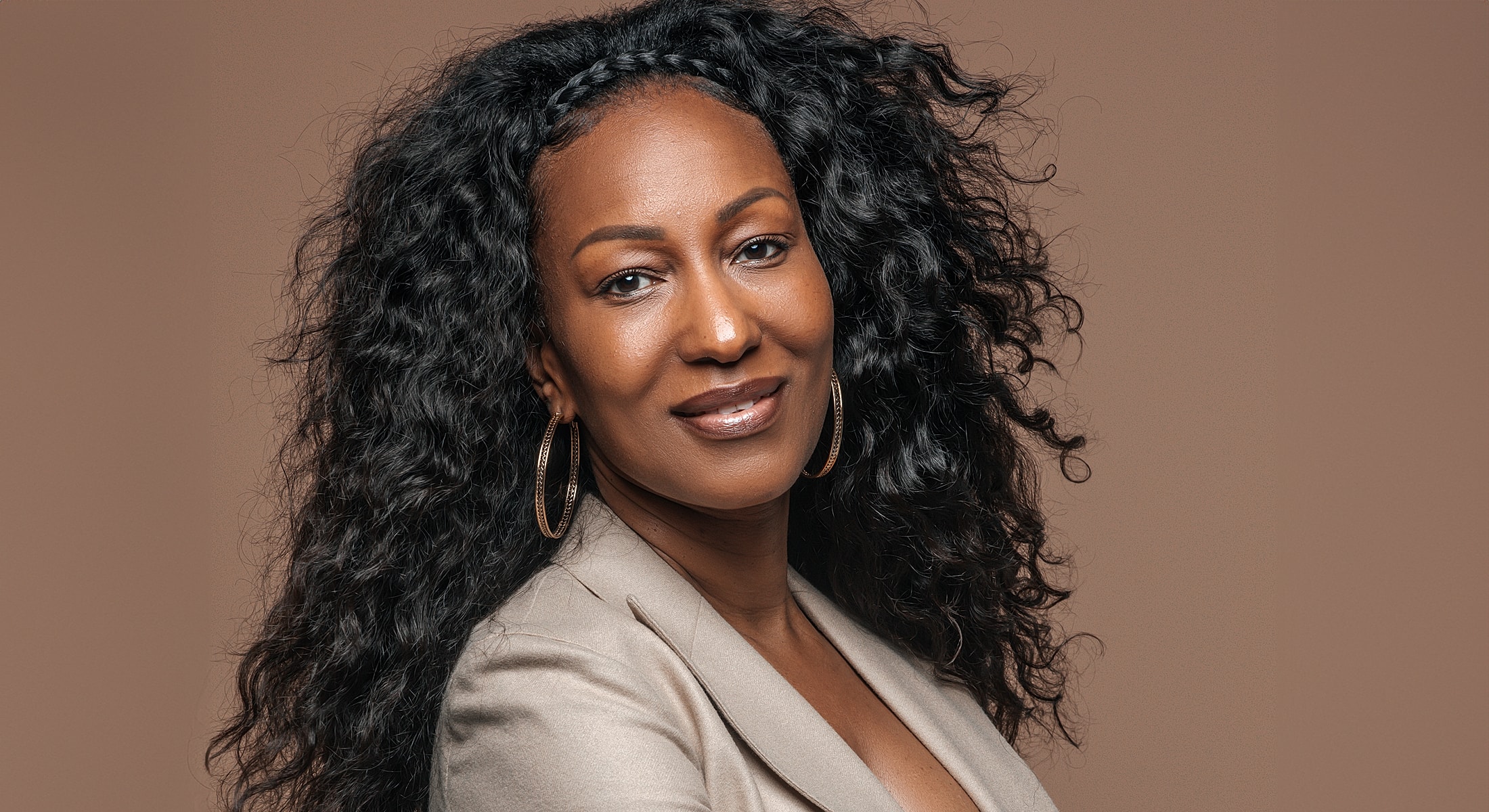 Abuja Botox model with curly hair and earrings.